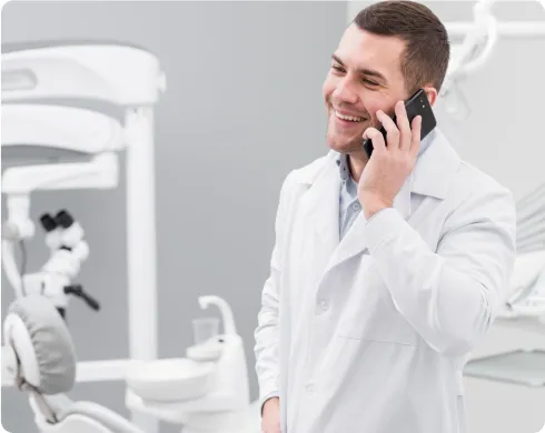 Dentist speaking on the phone to a patient Dentist speaking on the phone to a patient